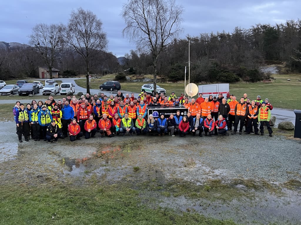 En gruppe frivillige redningsmannskaper har stilt seg opp til et gruppebilde.